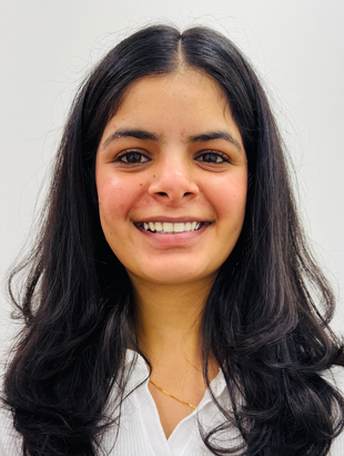 A close up of a woman 's face wearing a floral shirt and necklace.