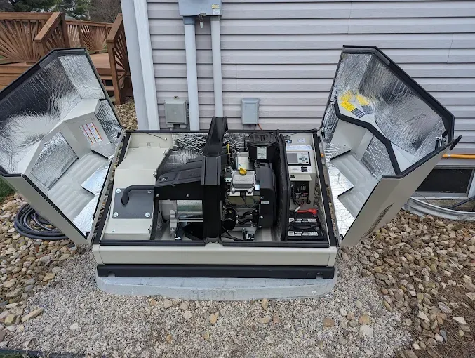 Man on ladder working on gutter of a house; wearing green shirt, gray shorts, near a window with shutters.