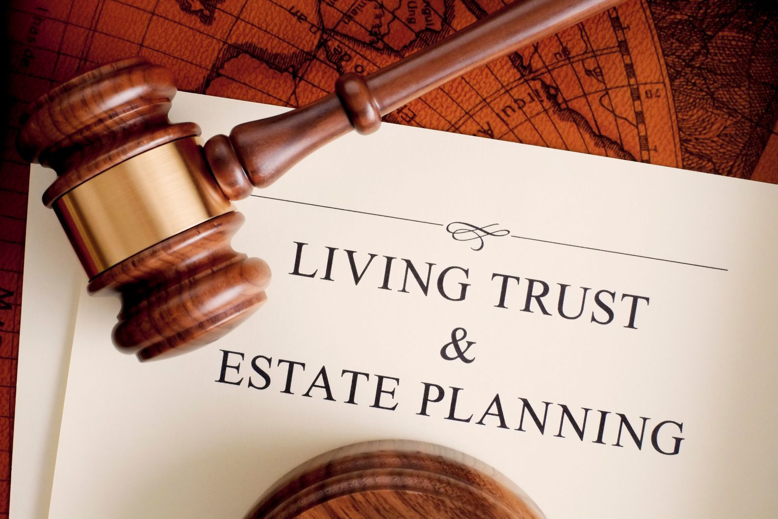 A wooden gavel is sitting on top of a piece of paper that says living trust and estate planning