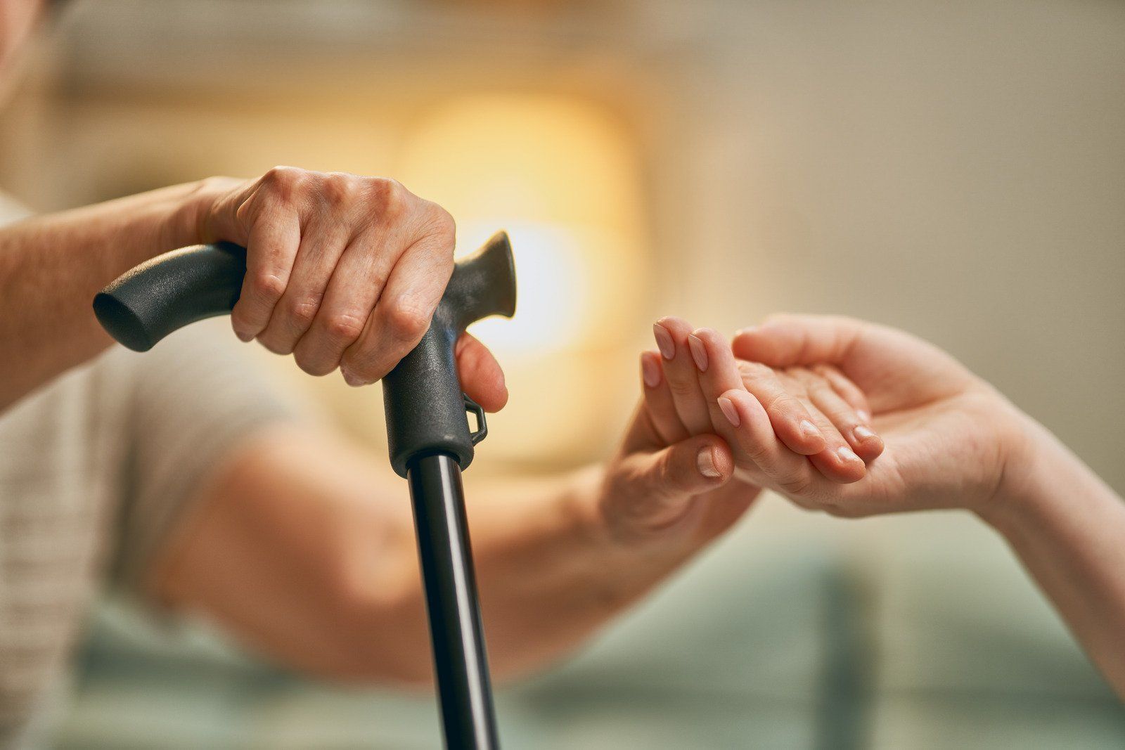 A man is holding a woman 's hand while holding a cane.