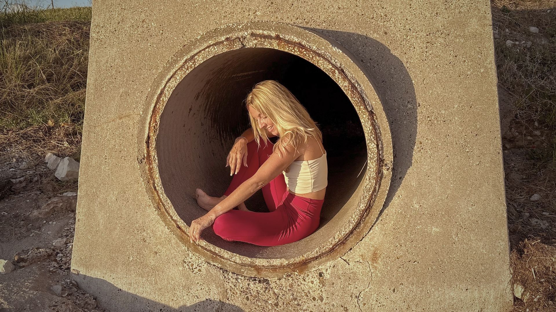 A woman is sitting in a manhole cover.