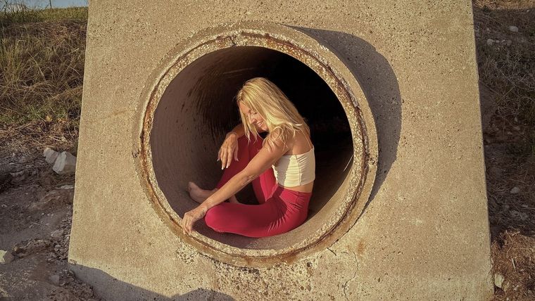 A woman is sitting in a manhole cover.