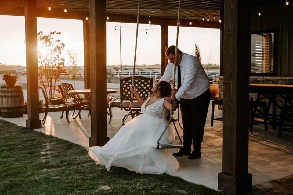 bride being pushed on swing by groom