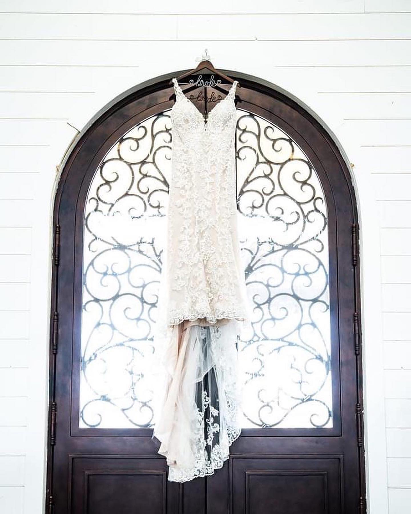 wedding dress hanging in front of window