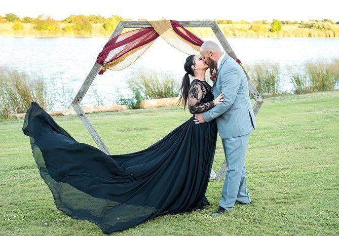 bride in black wedding dress kissing groom