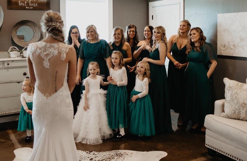 bride reacting to her bridesmaids and flower girls
