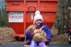 Kid Carrying a Dog - Dumpster Rental Company in Manchester, NH