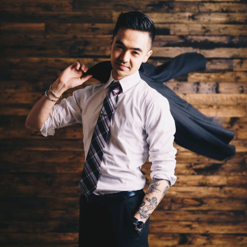 Investment Strategies - A man in a white shirt and tie is holding a black jacket over his shoulder