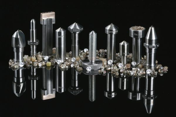 Un montón de objetos metálicos sobre una superficie negra.