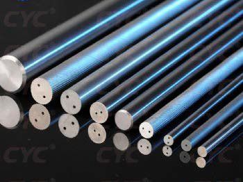 Un montón de varillas de metal están alineadas sobre una superficie negra.