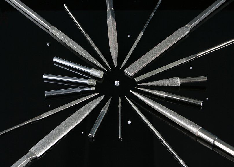 Un montón de diferentes tipos de objetos afilados sobre una superficie negra.