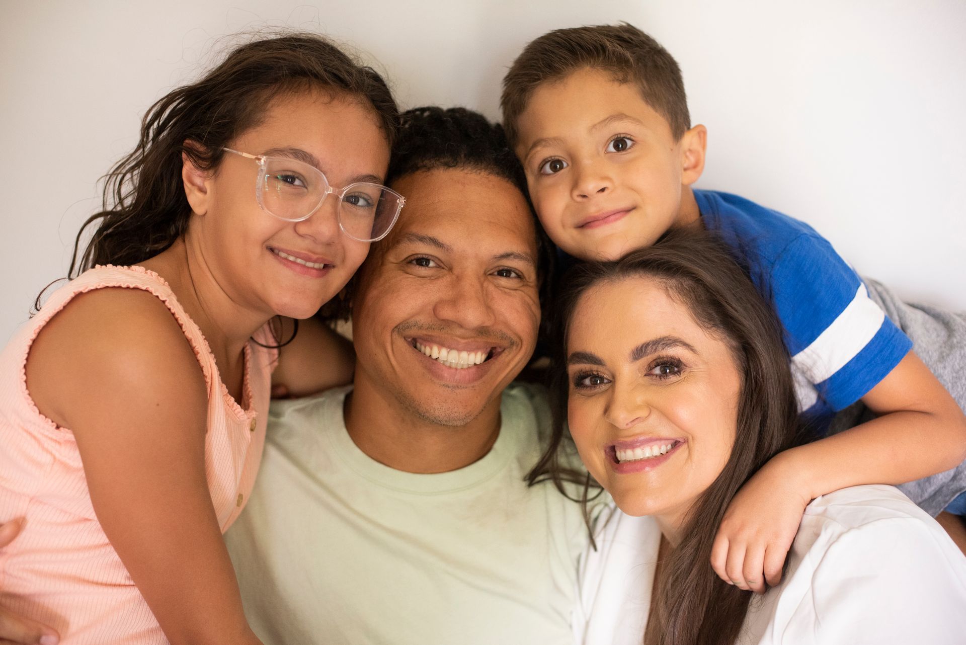 A family is posing for a picture together and smiling for the camera.