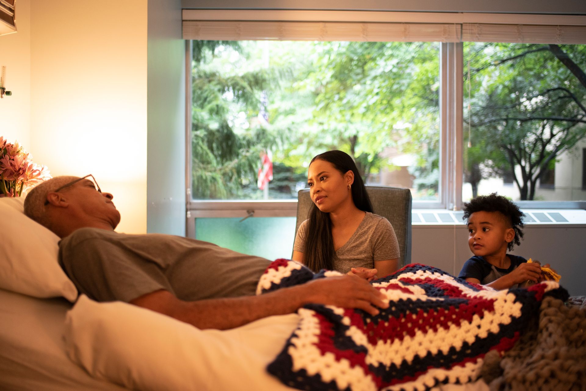 A man is laying in a hospital bed with his family.