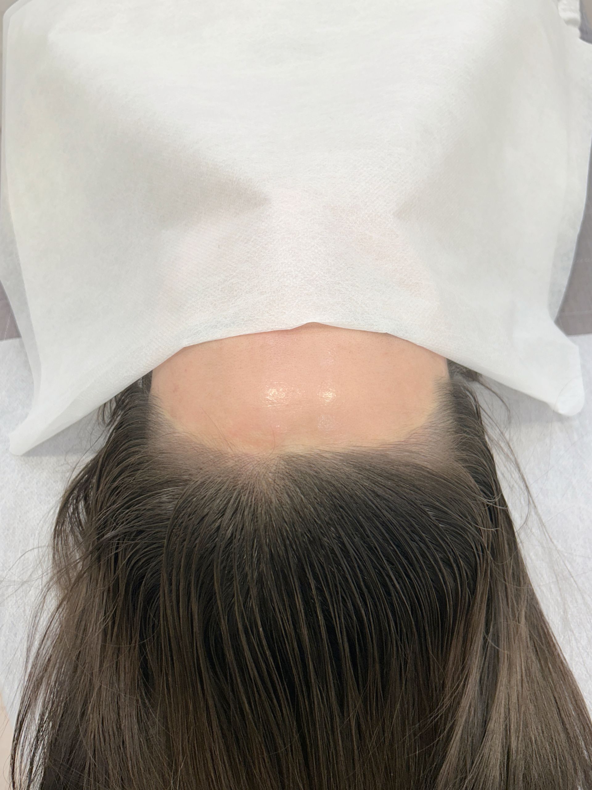 Close-up of a person's eye and face with eyebrow and beauty mark enhancements.