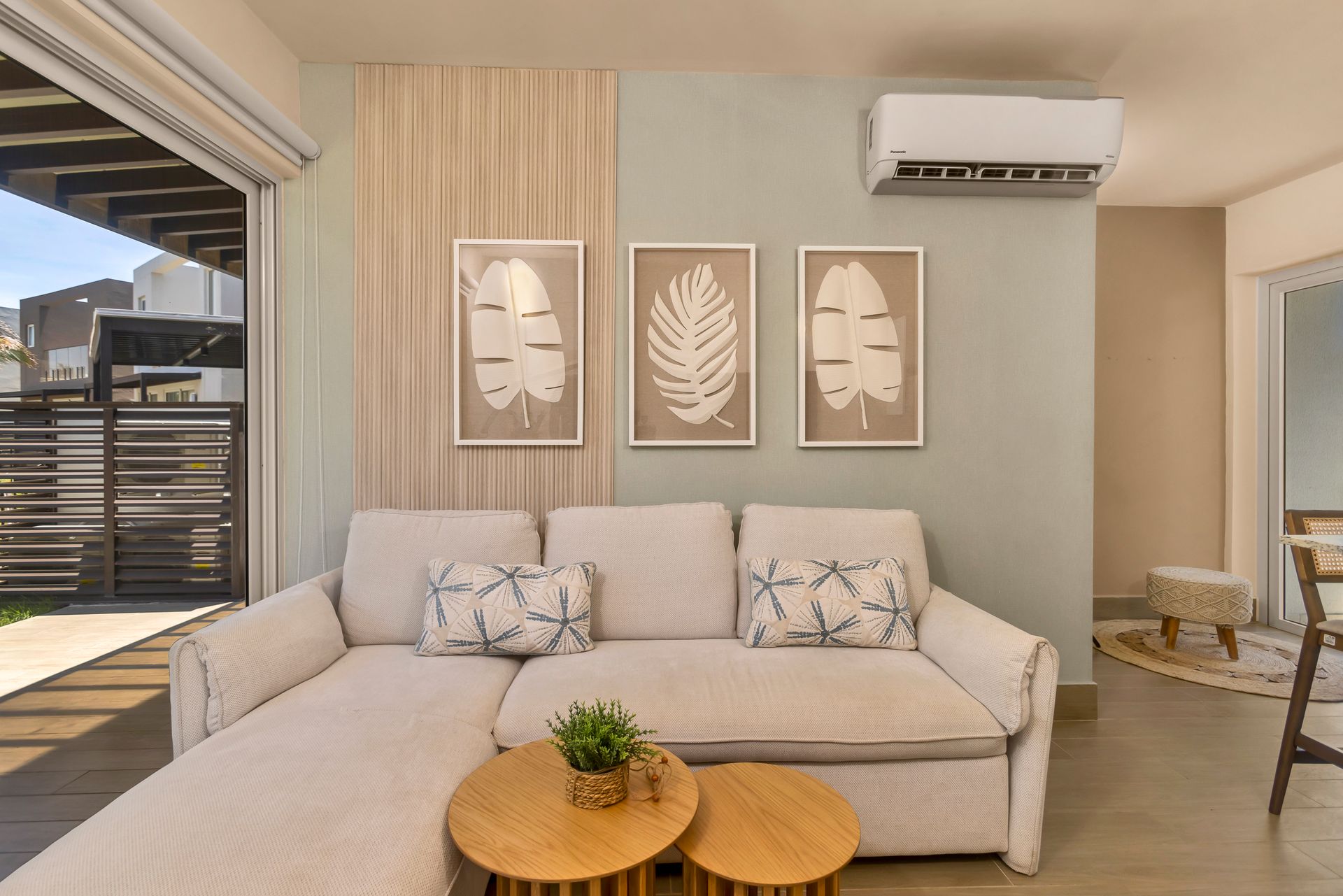 Living room with a light-colored sectional sofa, wall art, and a light green accent wall.