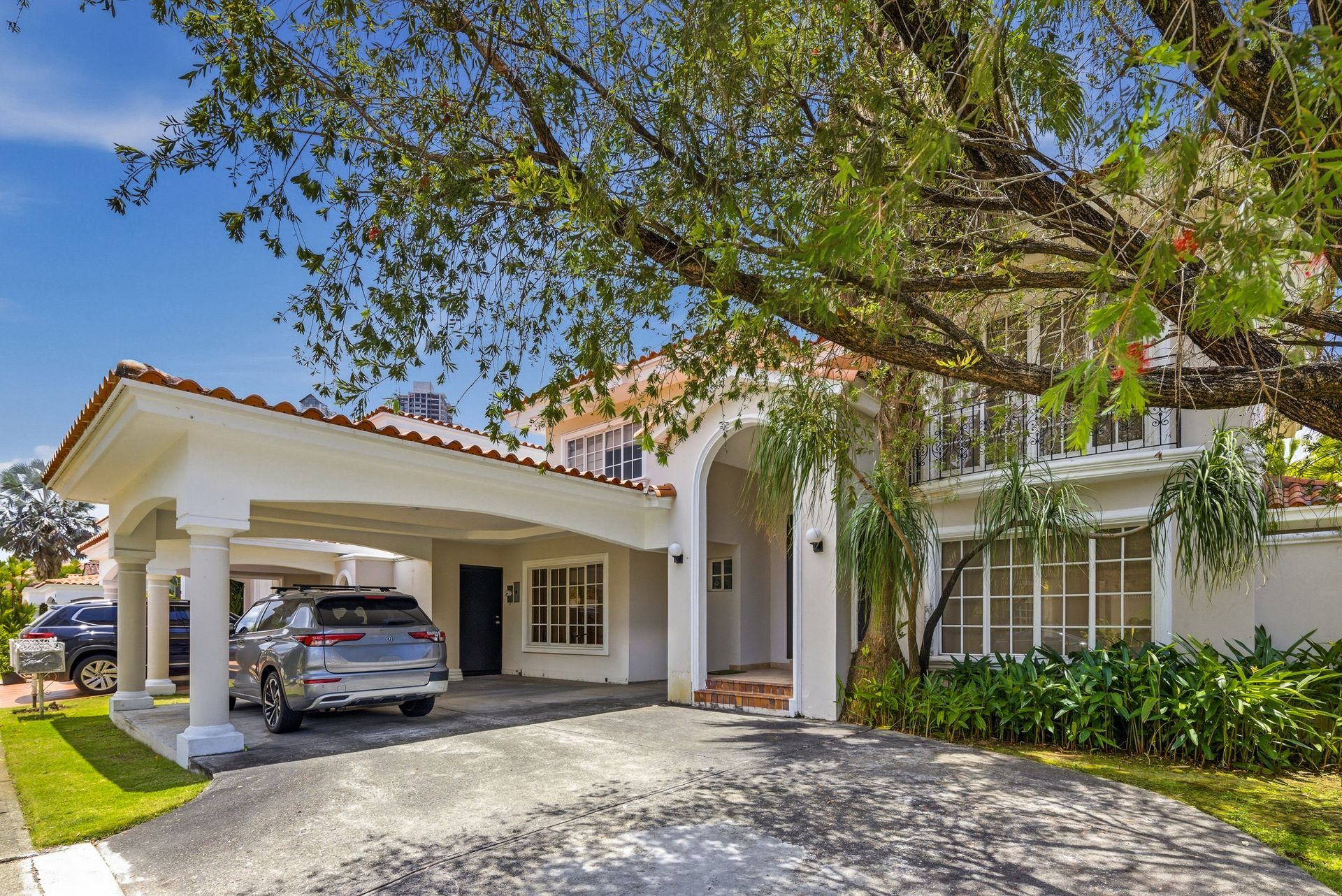 Wide angle of Costa del Este luxury home facade and carport, Panama City residential architecture.