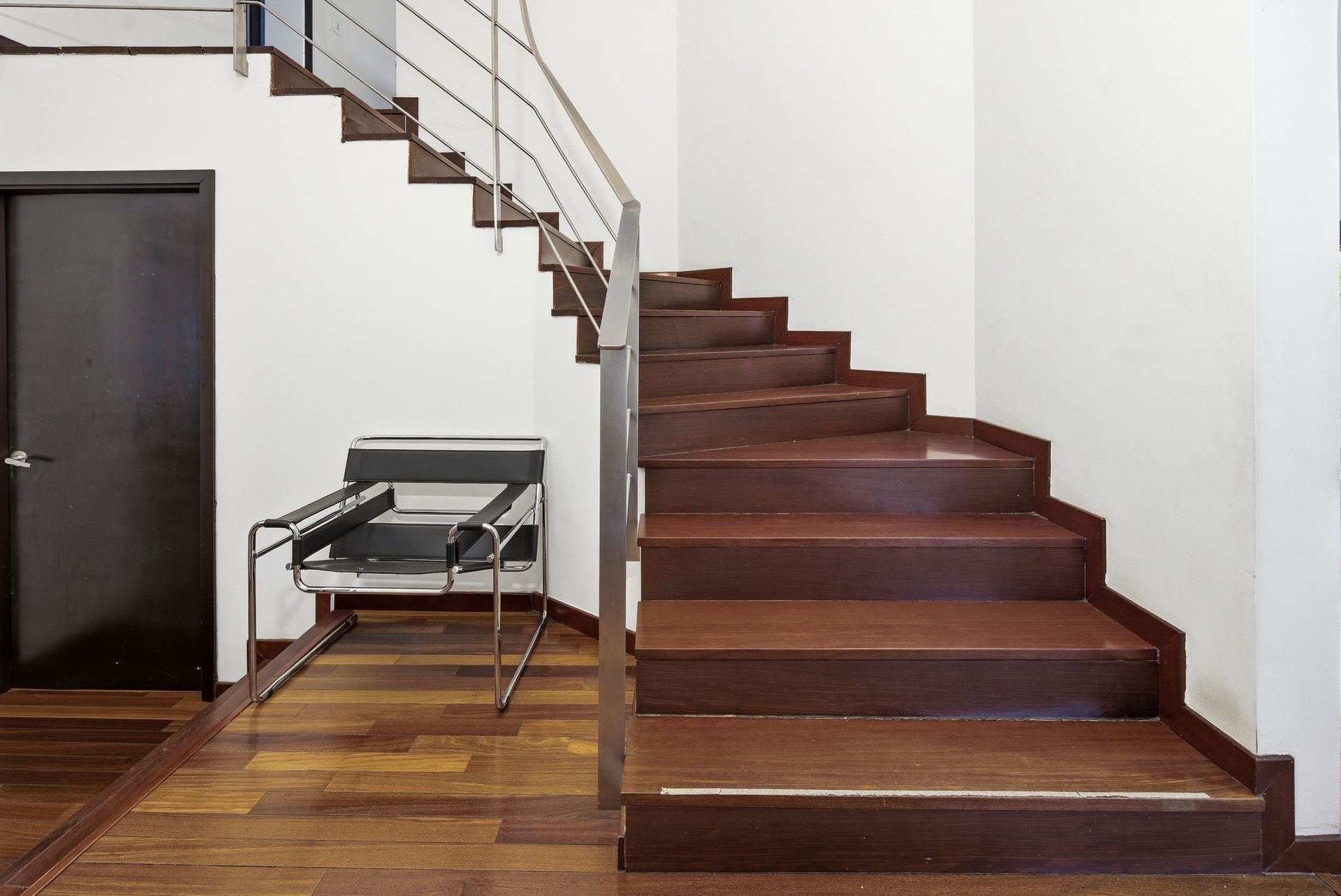 Costa del Este home entrance hall with modern wooden staircase and designer seating, Panama luxury real estate.