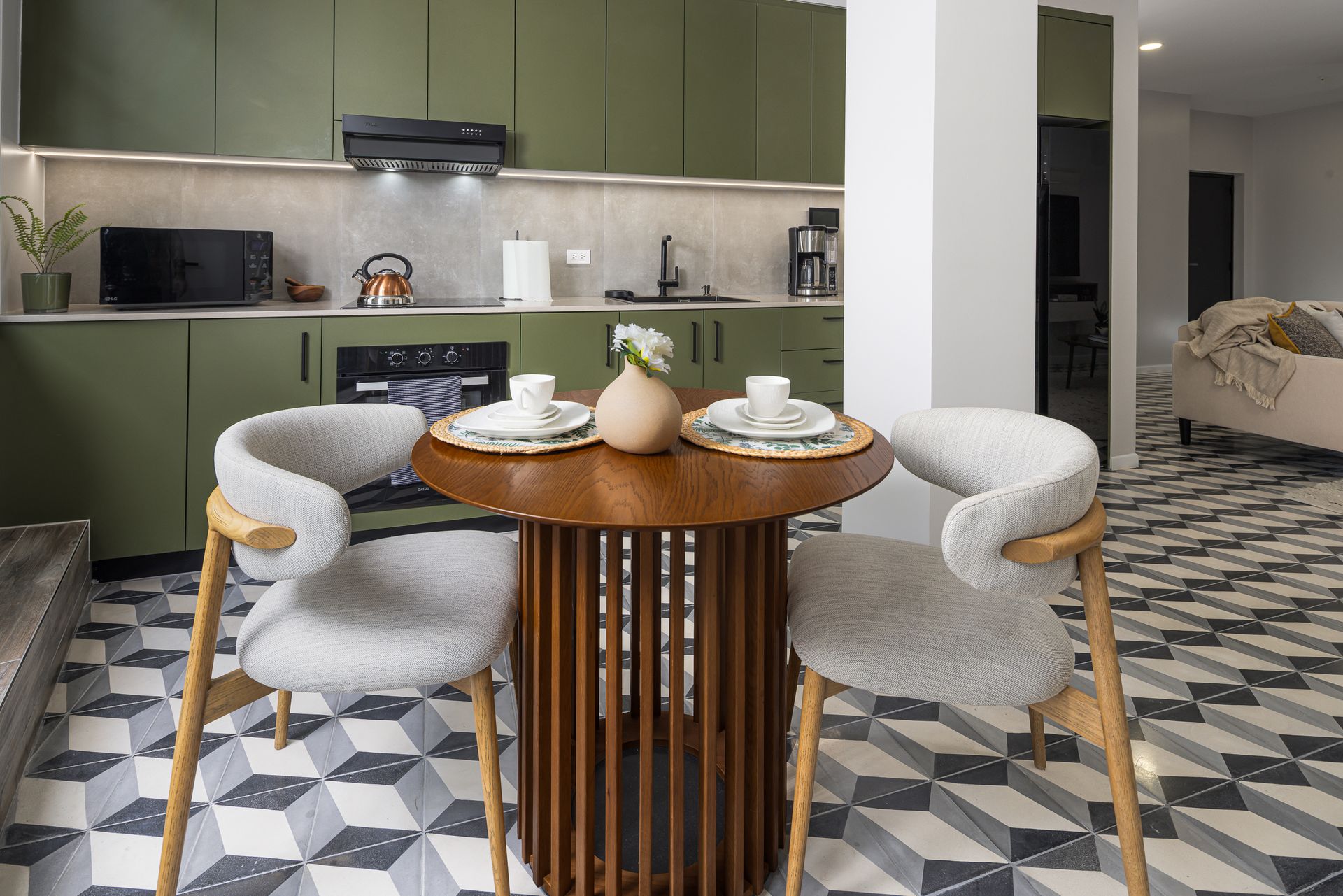 Boutique dining area with round wooden table and historic hydraulic floor tiles in Mansión Baluarte Casco Viejo