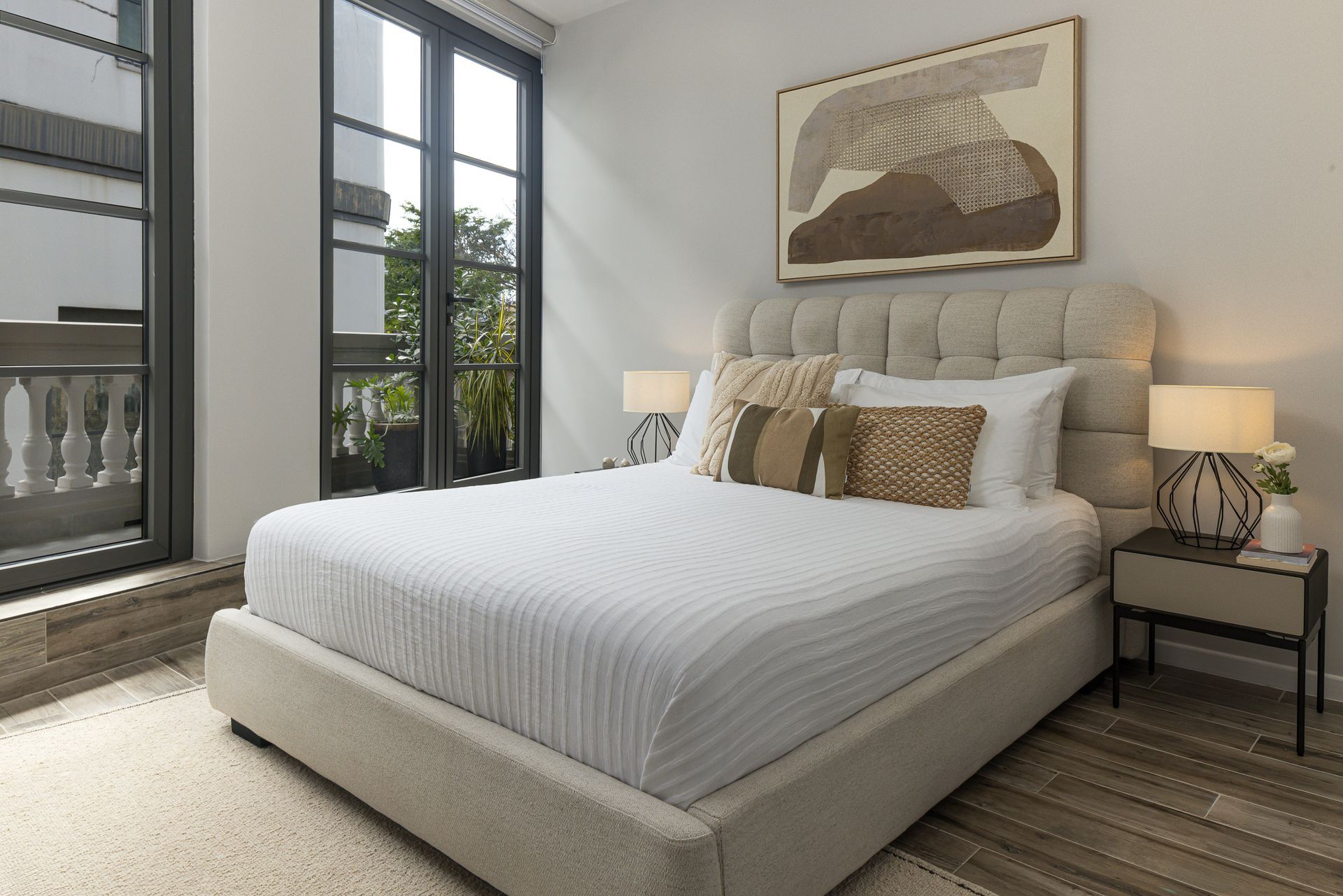 Luxury bedroom interior with neutral tones and historic balcony access in Mansión Baluarte, Casco Viejo.