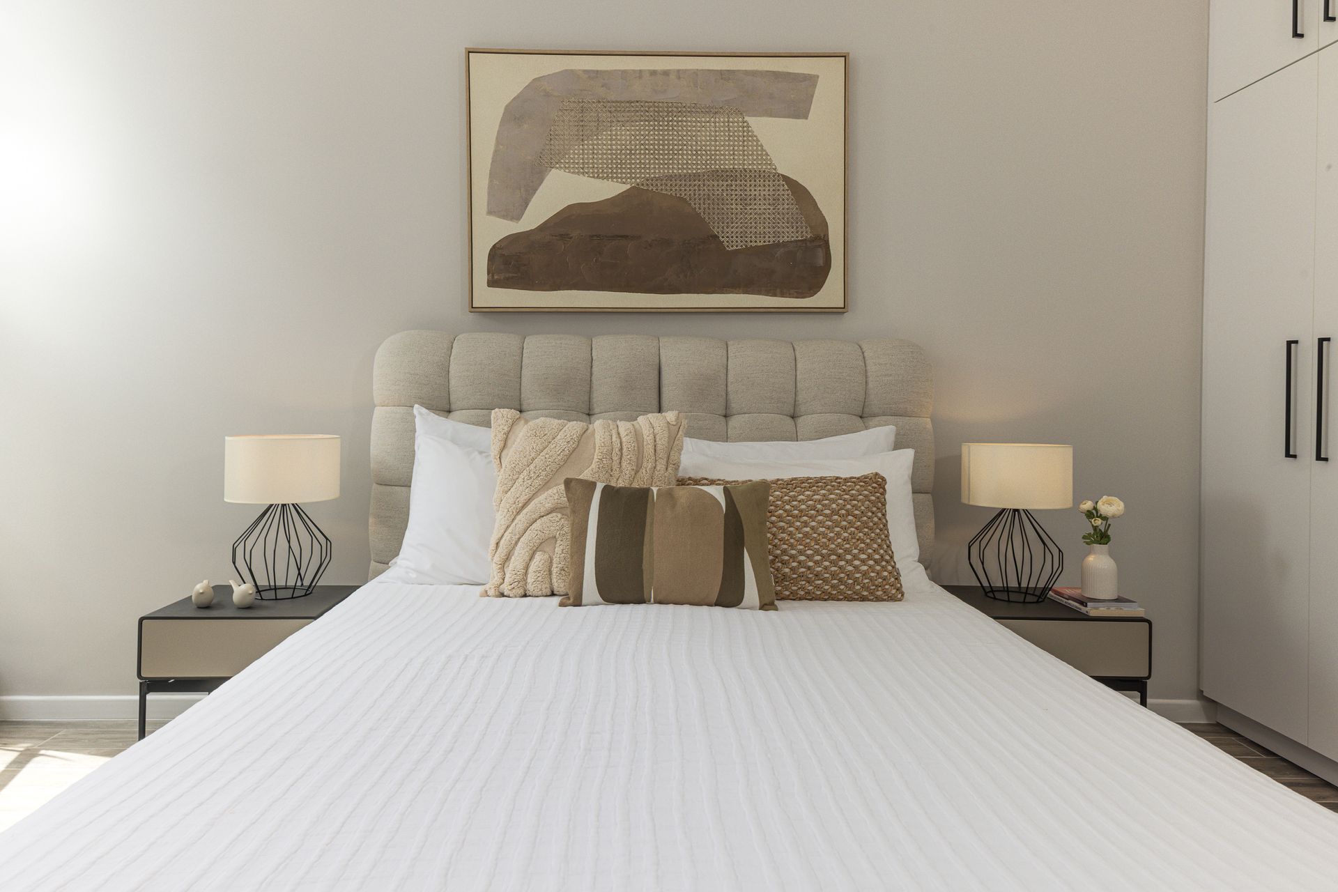 Luxury boutique Airbnb master bedroom with white bedding and abstract art in Mansión Baluarte Casco Viejo Panama