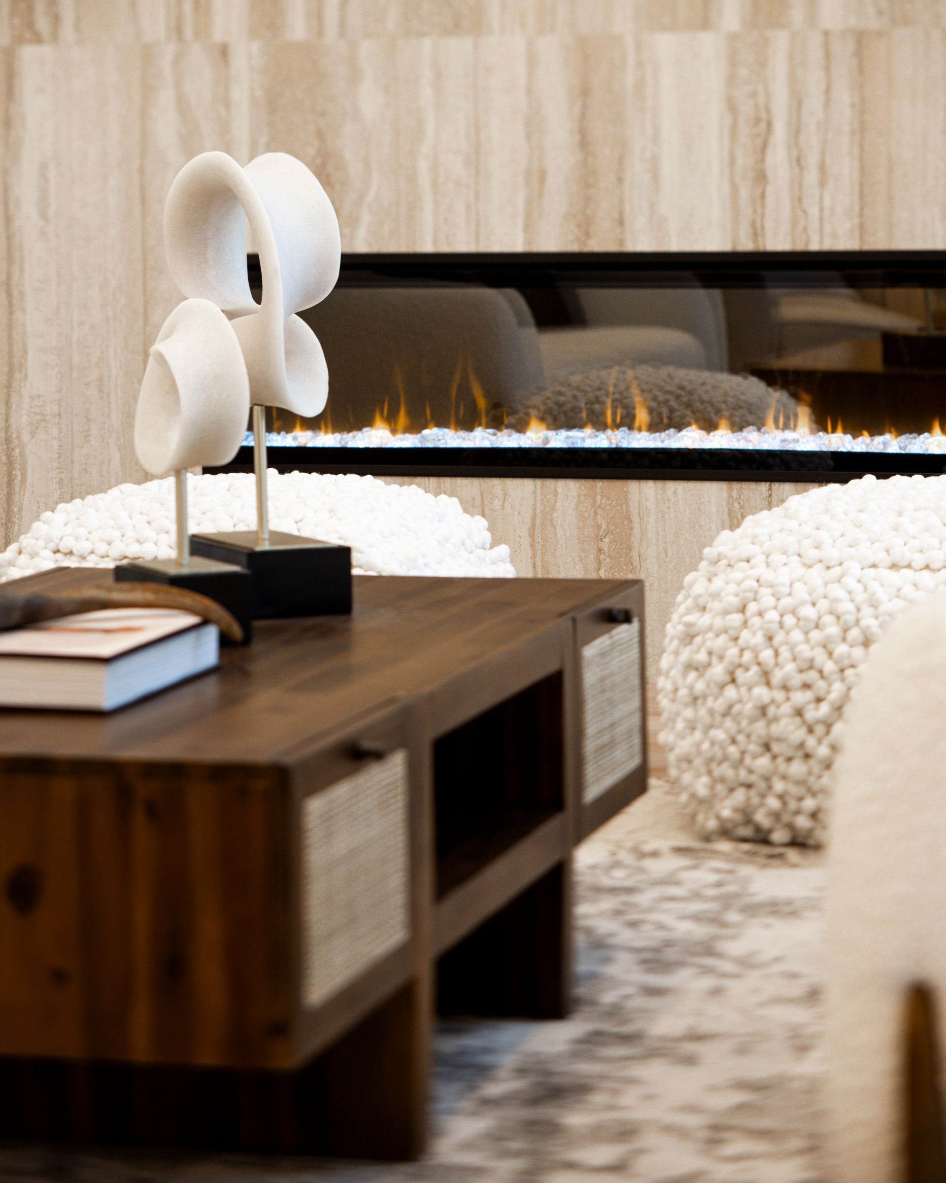Living room with fireplace, wooden coffee table, and decorative sculpture.