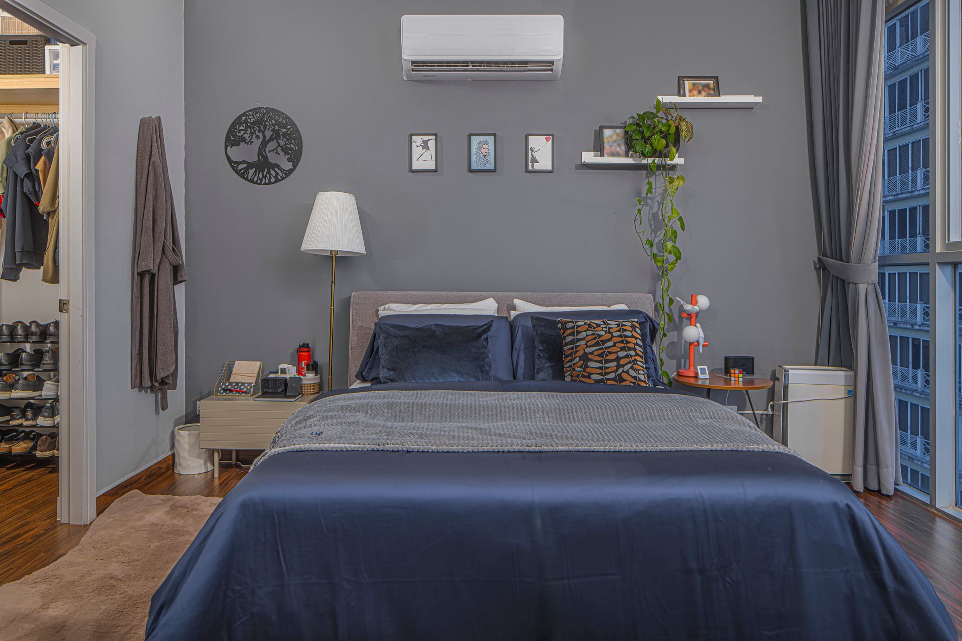 Bedroom with a gray wall, bed with blue bedding, and a walk-in closet.