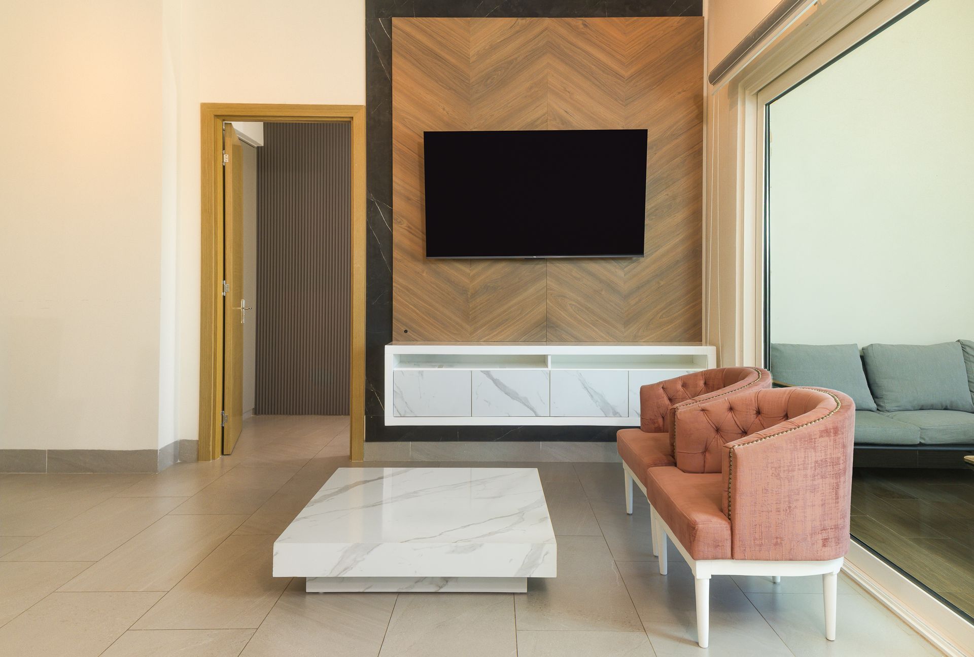 Modern living room with blush sofa and balcony view in short-term rental at Playa Escondida Resort