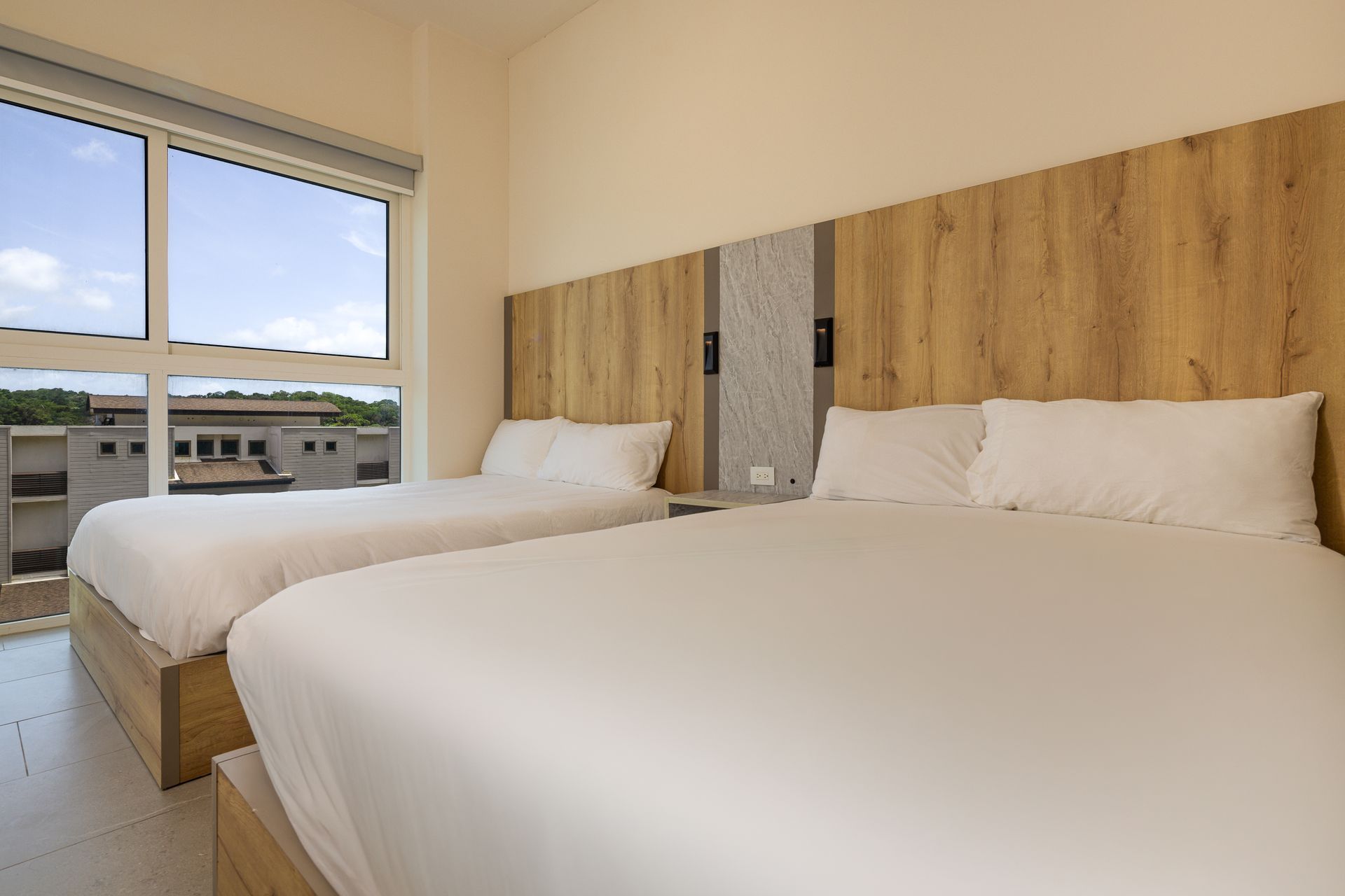 Bright bedroom with wooden headboard and ocean-facing window at Playa Escondida, Panama