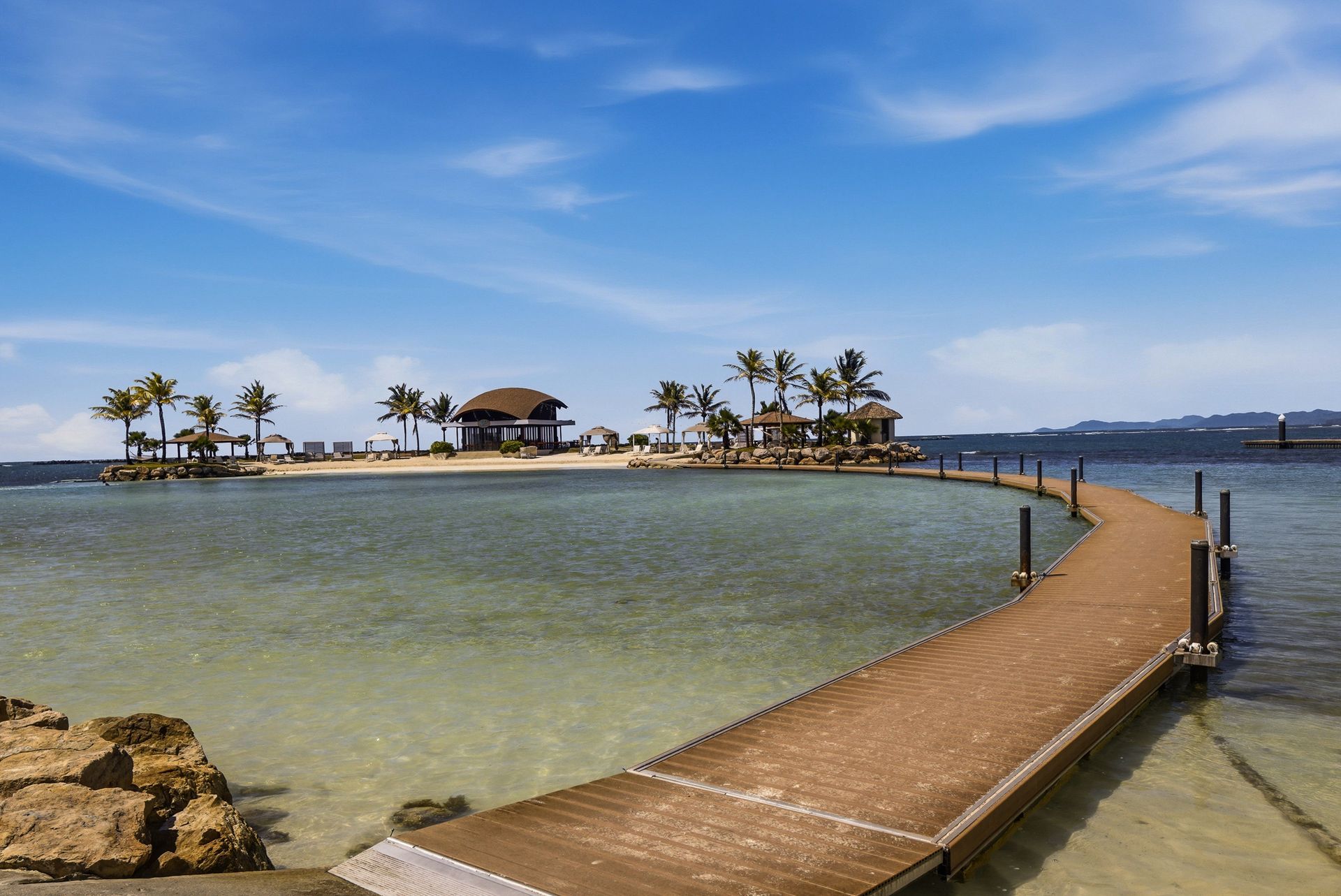 Turquoise Caribbean beach with wooden dock and palms at Playa Escondida Resort, Colón, Panama