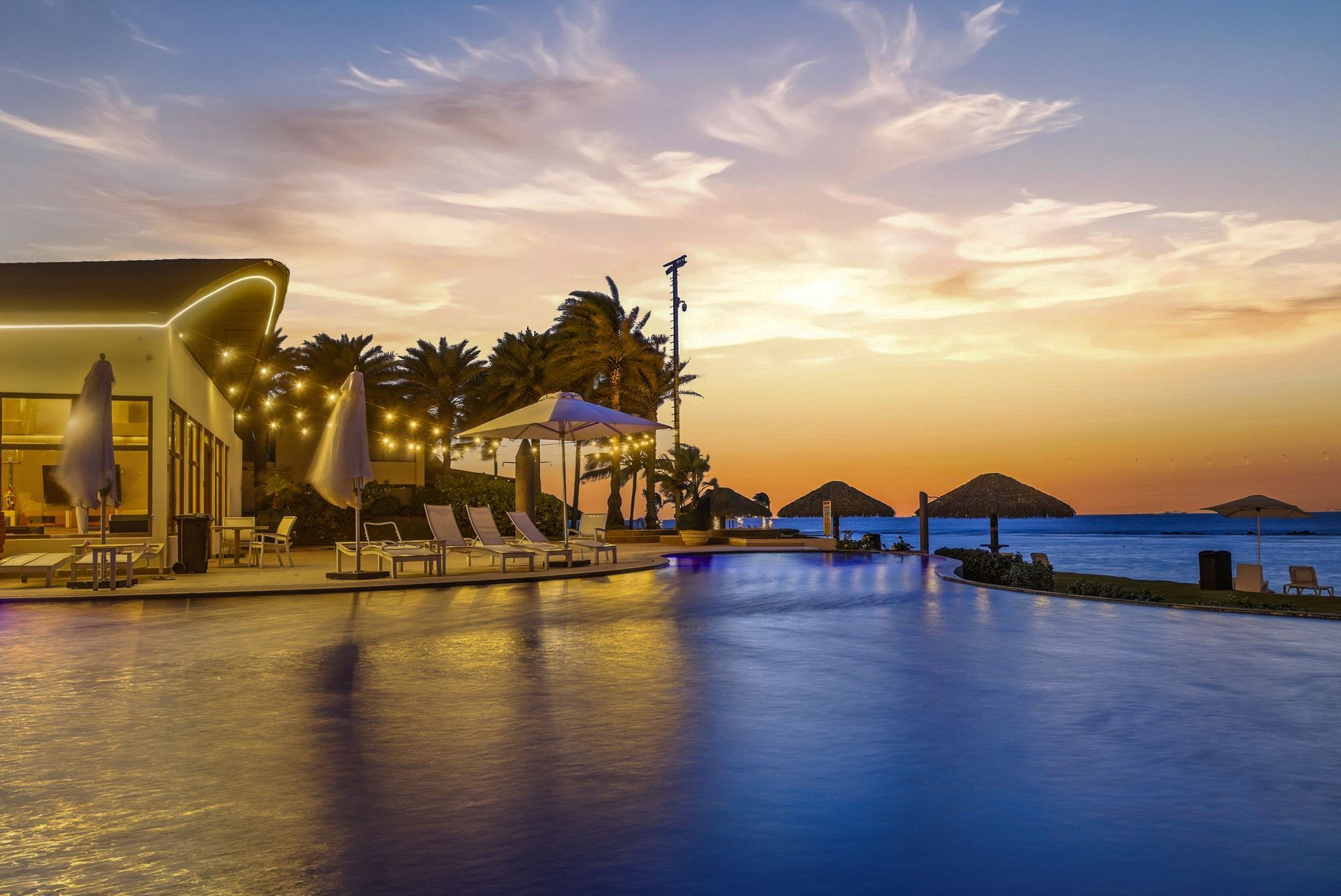Twilight view of resort pool with string lights at sunset, Playa Escondida, Panama Caribbean