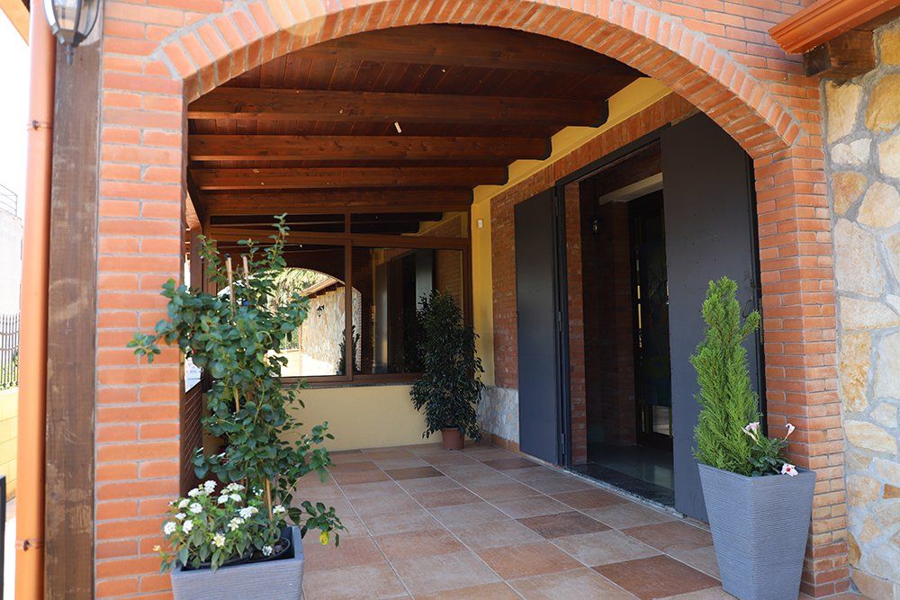 Un portico con un arco in mattoni e piante in vaso