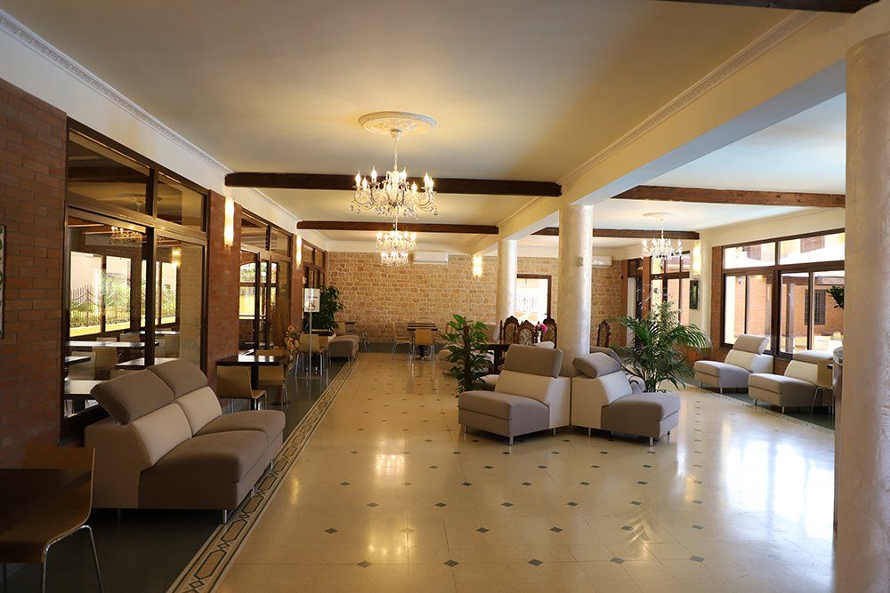 Una grande hall con molti mobili e un lampadario.