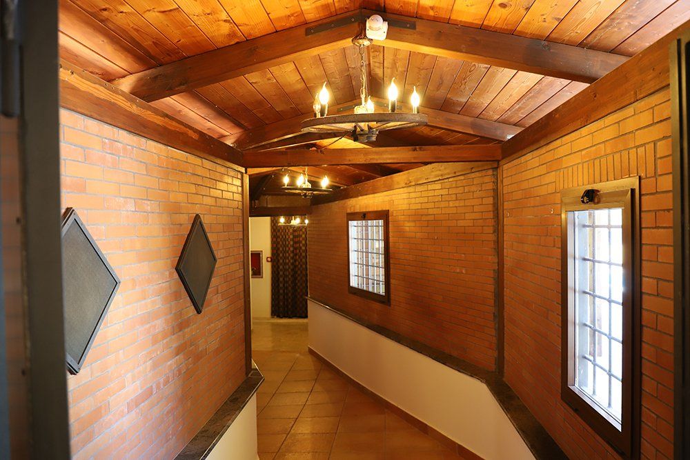 Un lungo corridoio con pareti in mattoni e soffitto in legno