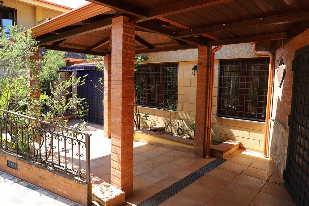 Un edificio in mattoni con un portico in legno e una recinzione