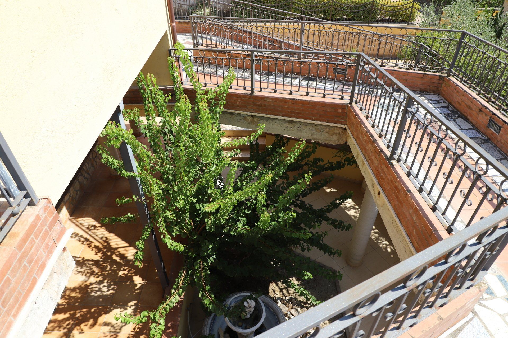 Una vista aerea di un balcone con scale e un albero