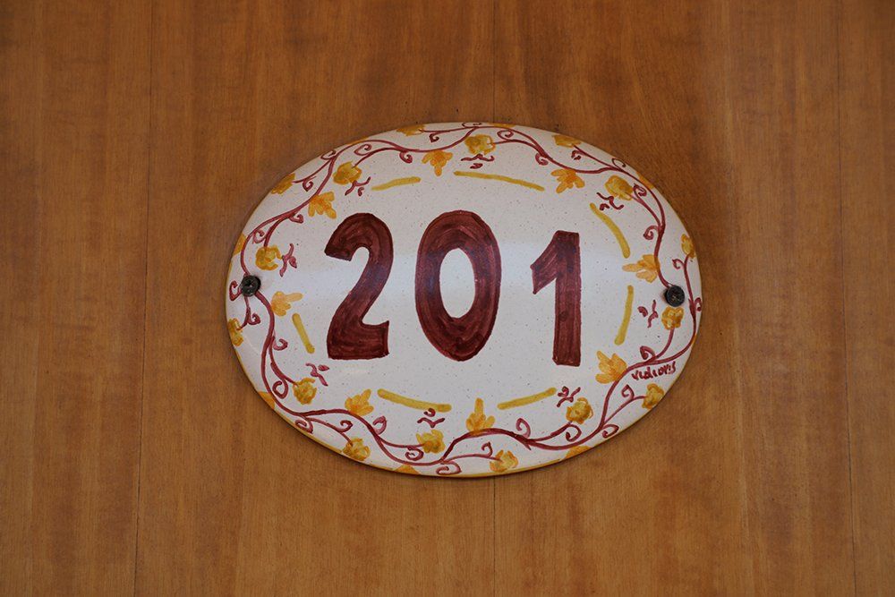 Un cartello su un muro di legno che dice 201