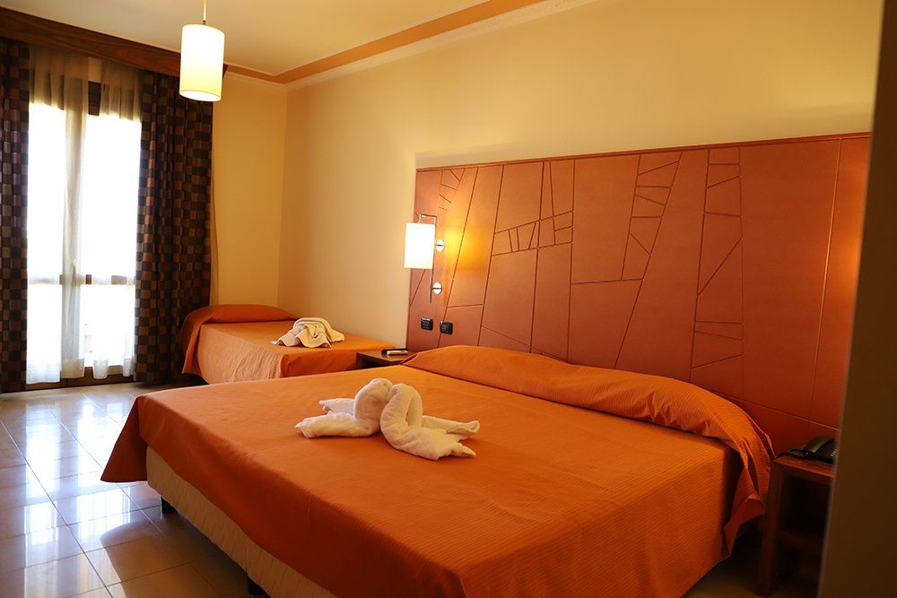 Una camera d'albergo con un letto king size e due letti singoli