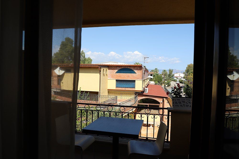 Un balcone con tavolo e sedie e vista sulla città