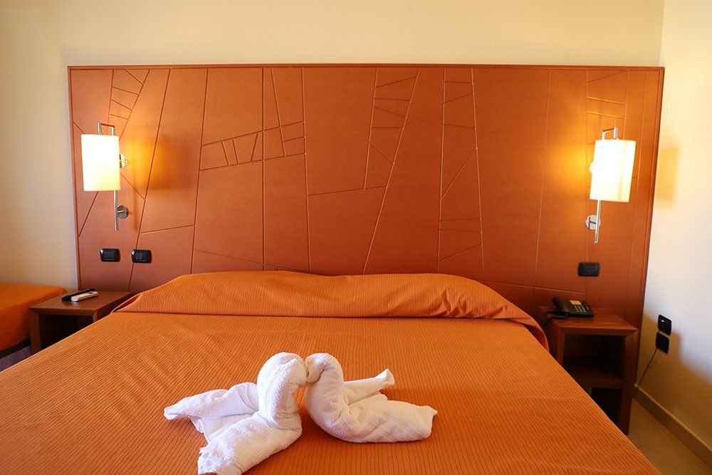 Una stanza d'albergo con un letto e due asciugamani sopra