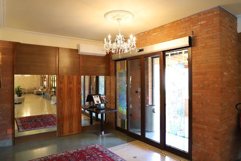 Un'ampia hall con un lampadario appeso al soffitto e un muro di mattoni.