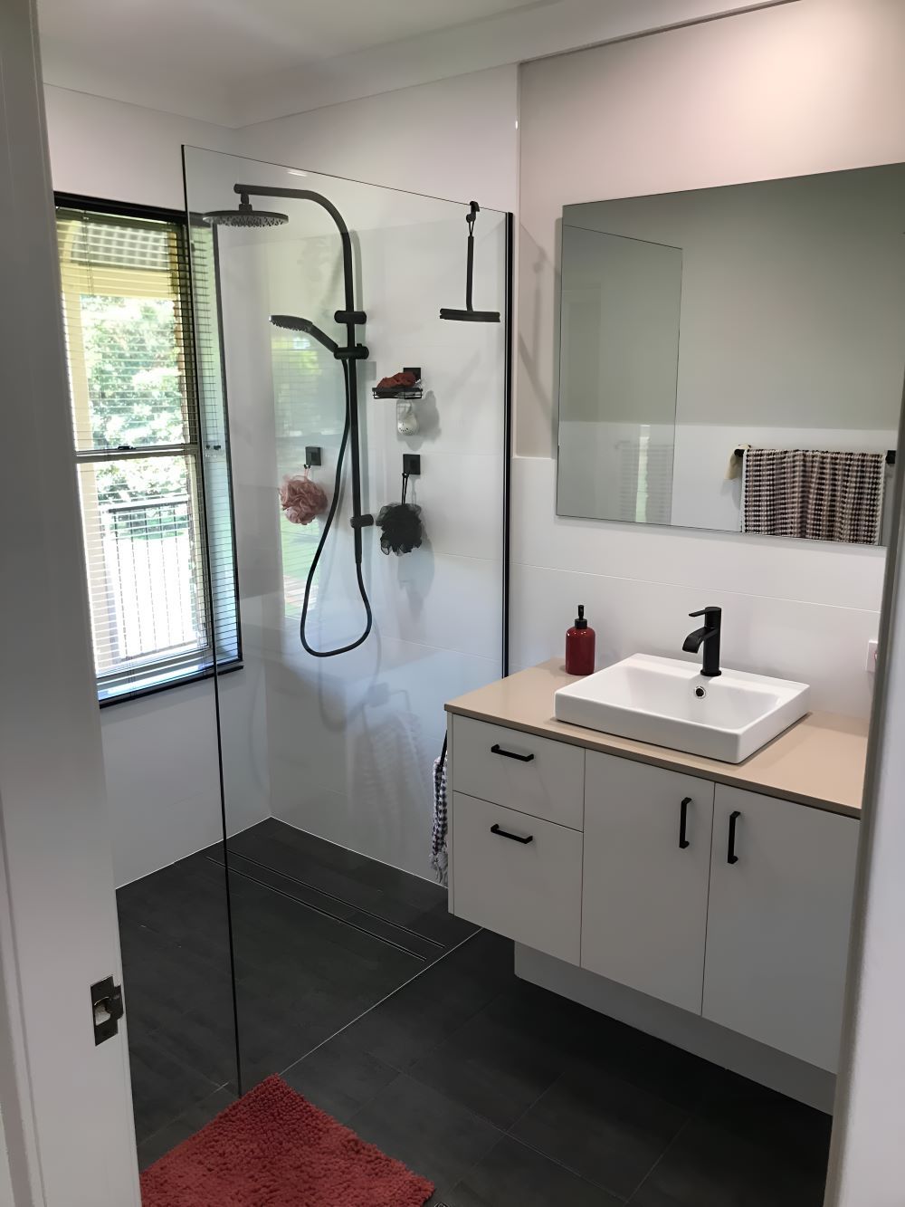 A Bathroom With A Sink, Mirror, And Shower — Coffs Coast Designer Bathrooms in Toormina, NSW