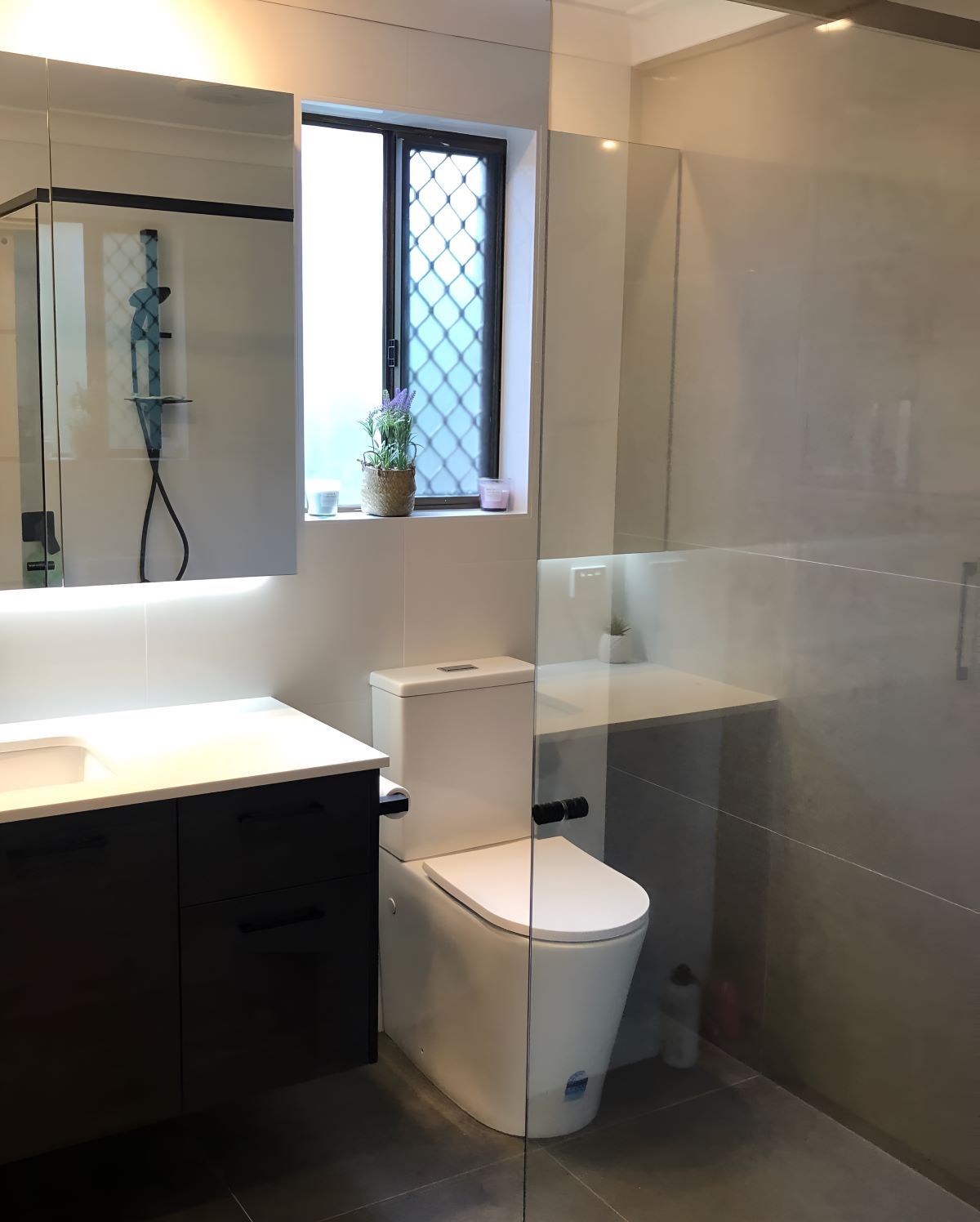 A Bathroom Renovation With A Toilet A Sink And A Window — Coffs Coast Designer Bathrooms in Coffs Harbour, NSW