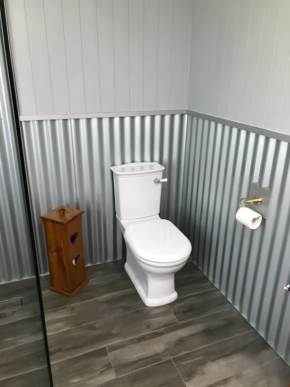 A Bathroom Featuring A Toilet And A Wooden Box On The Floor — Coffs Coast Designer Bathrooms in Bellingen, NSW