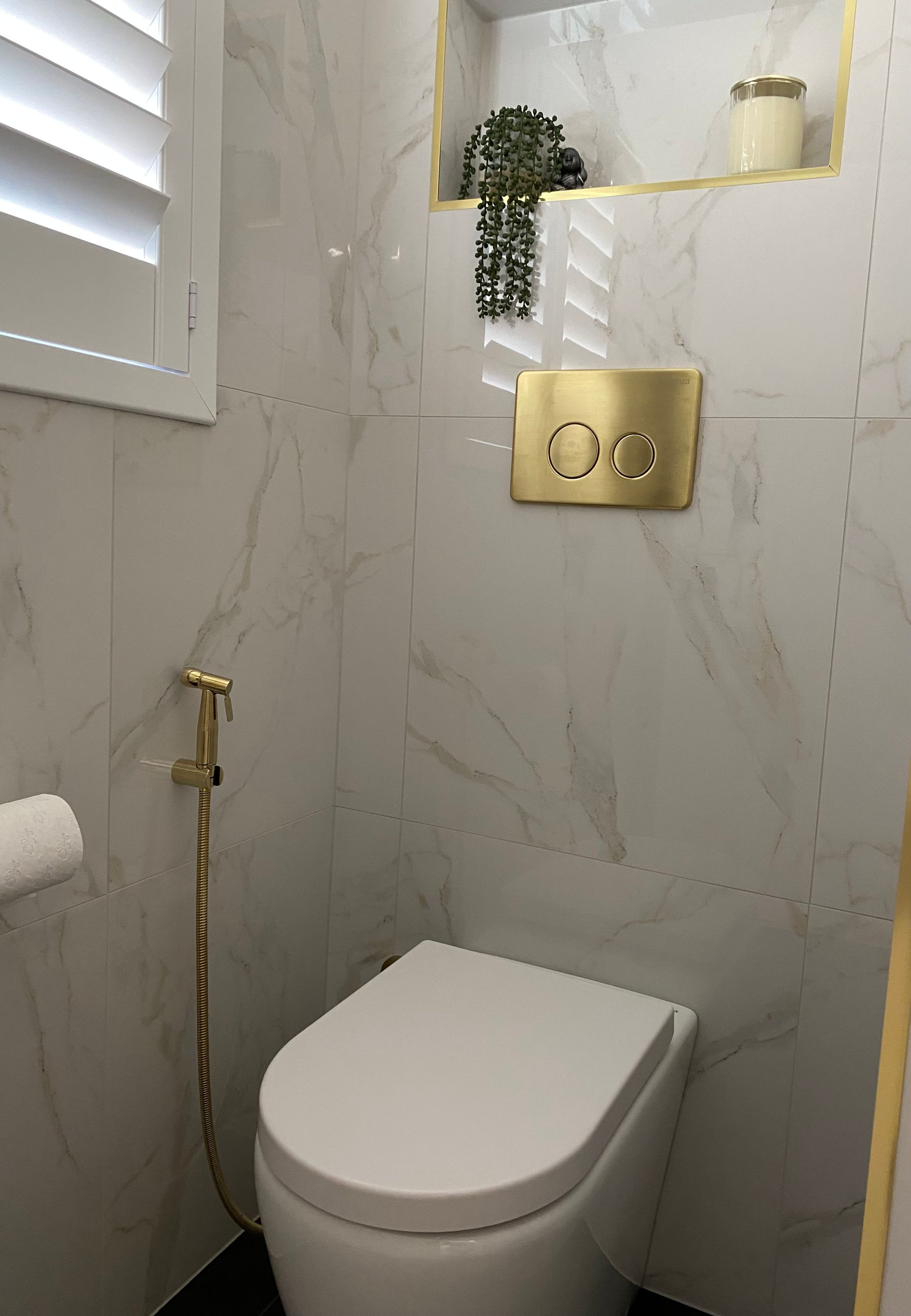 A Toilet With A Bidet Attached To It In A Bathroom — Coffs Coast Designer Bathrooms in Toormina, NSW