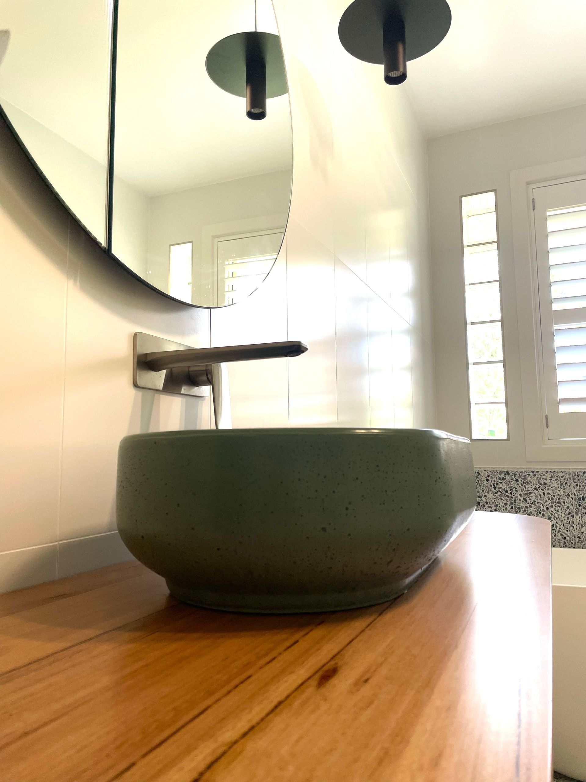 A Green Sink Is Sitting On A Wooden Counter In A Bathroom — Coffs Coast Designer Bathrooms in Toormina, NSW