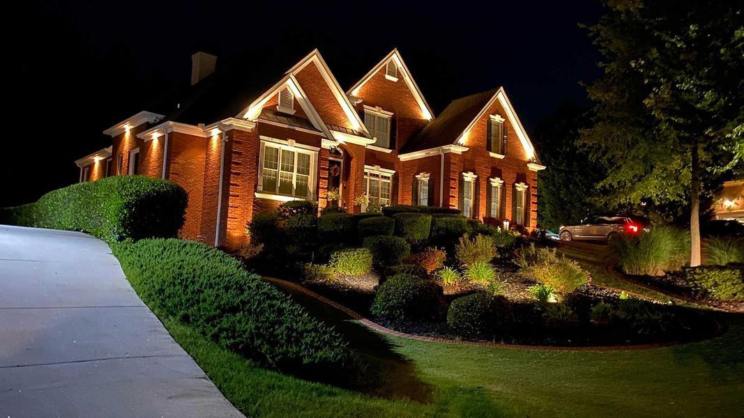 A large brick house is lit up at night.