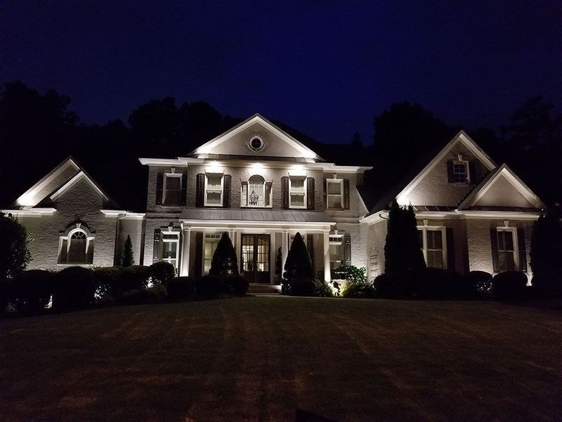 A large white house is lit up at night