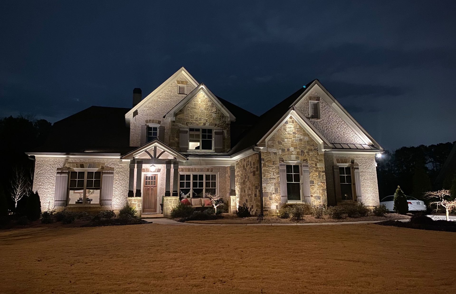 A large stone house is lit up at night.