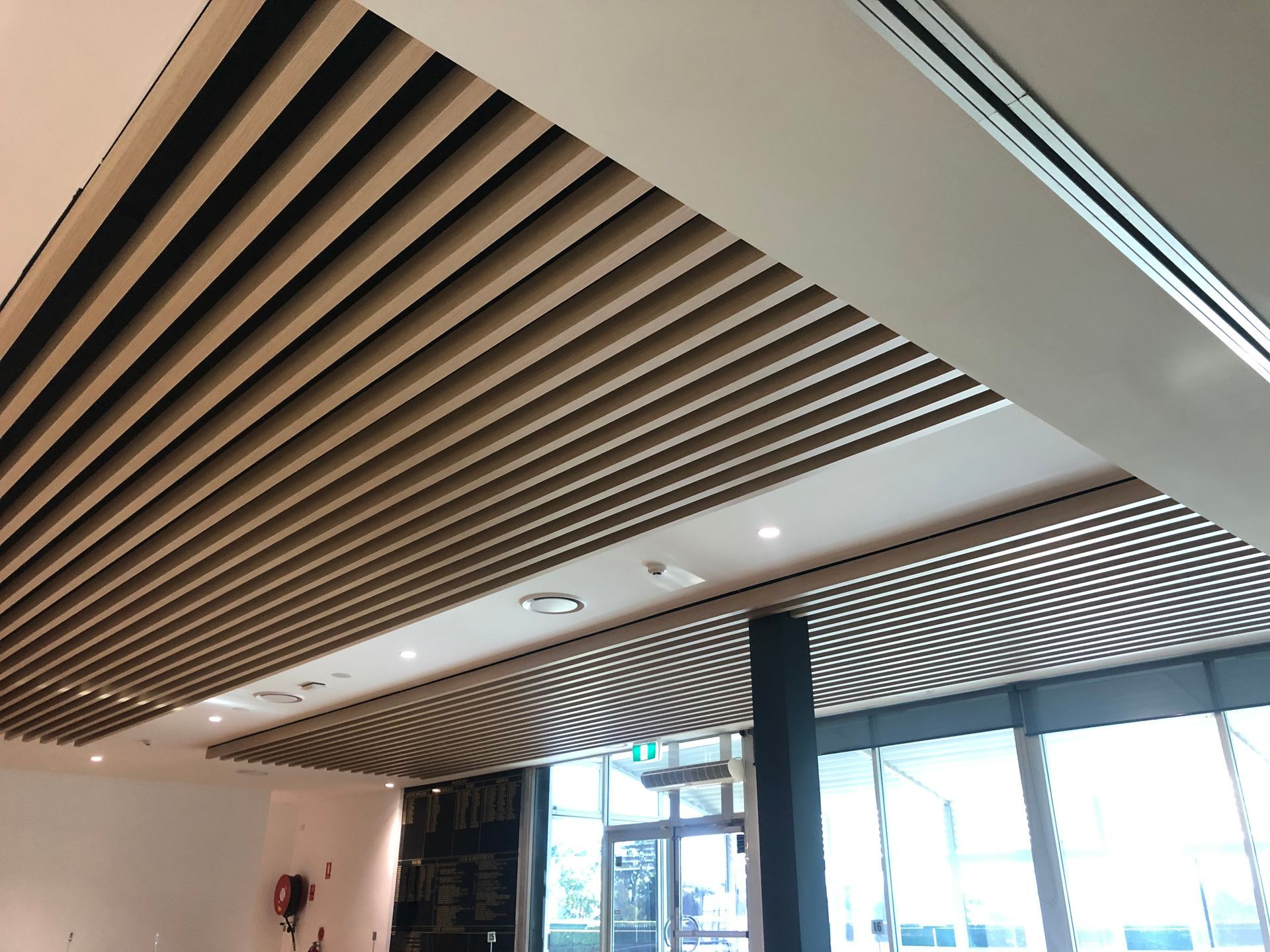 A Man Is Standing on A Ladder Painting a Ceiling — Highline Carpentry in Kahibah, NSW