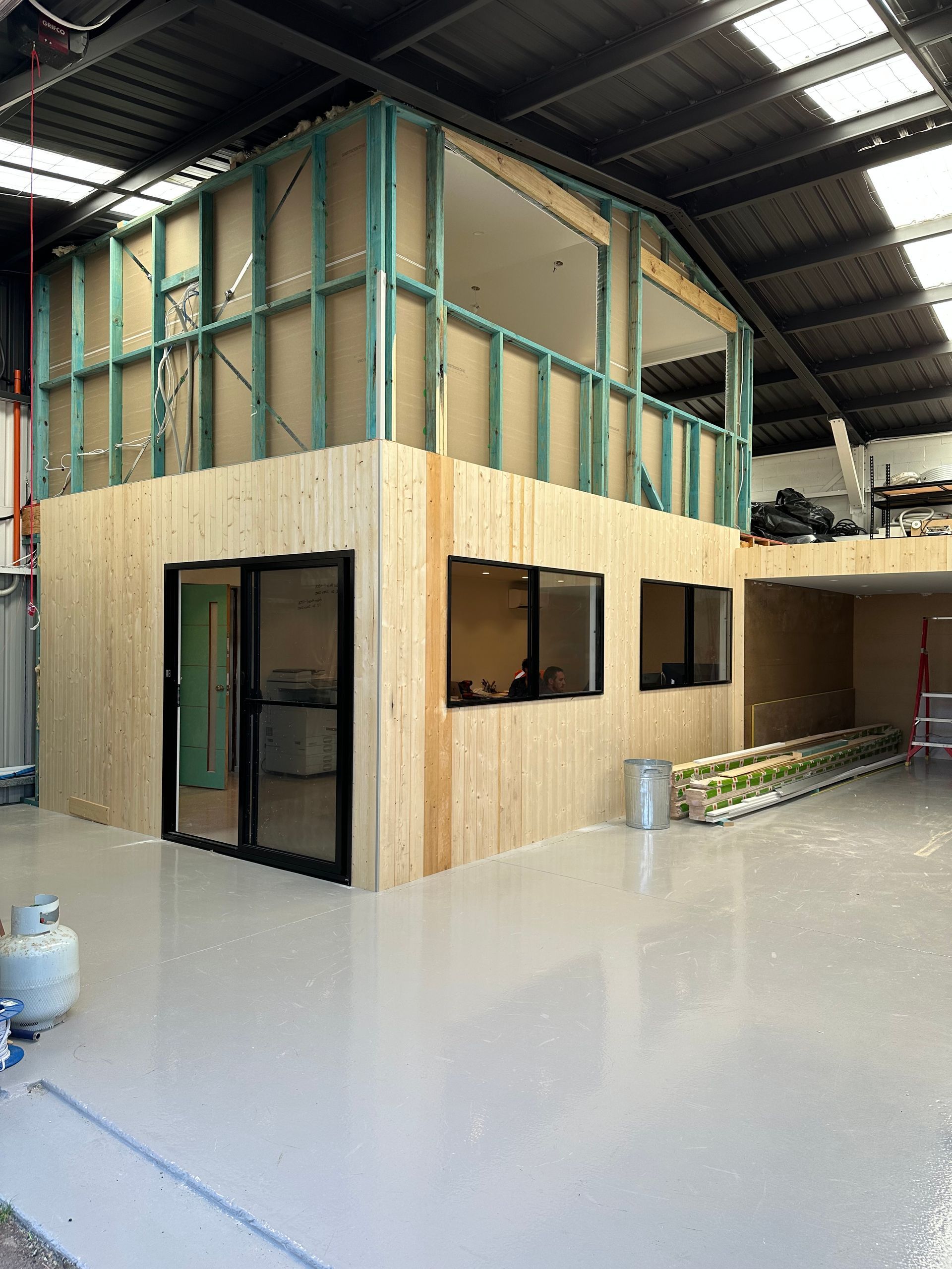 A Man Is Installing a Window in A House — Highline Carpentry in Kahibah, NSW